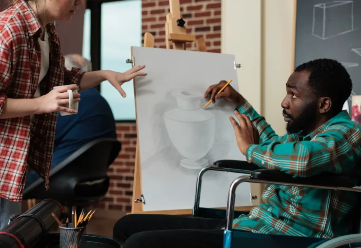 artist-in-wheelchair-receives-guidance-on-a-drawing
